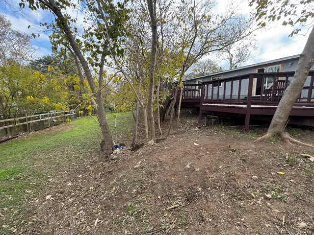 a view of a backyard with a large tree and a deck