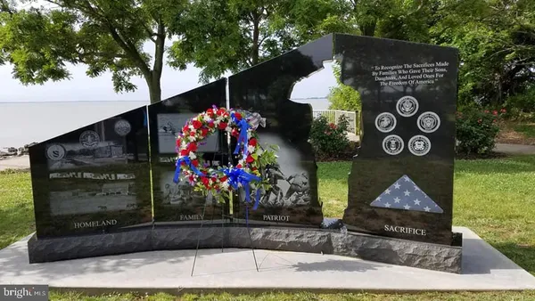 a front view of a house with a yard and sign board
