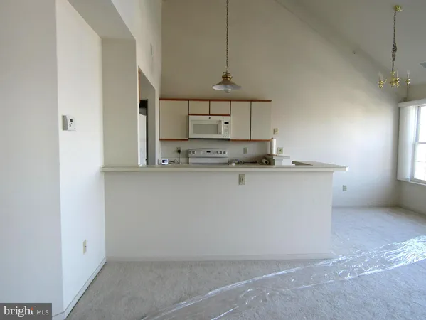 a view of kitchen with kitchen island white cabinets and stainless steel appliances