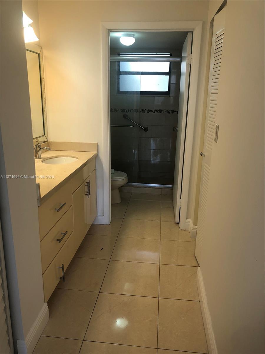 8100 Byron Avenue, Unit 509 Miami Beach, FL 33141 - Photo 7 of 18 a bathroom with a sink a toilet and a mirror