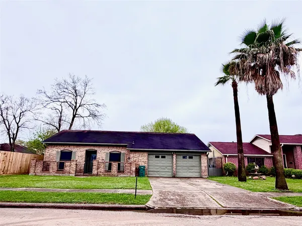 a front view of a house with a garden and plants
