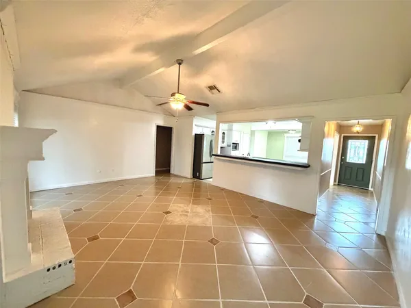 a view of a livingroom with a chandelier fan and windows