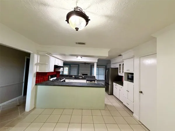 a kitchen with stainless steel appliances kitchen island granite countertop a refrigerator and a stove