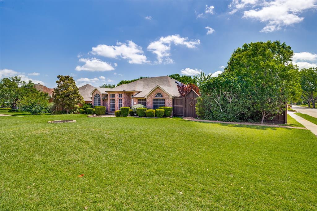 Expansive front lawn with mature trees and established landscaping