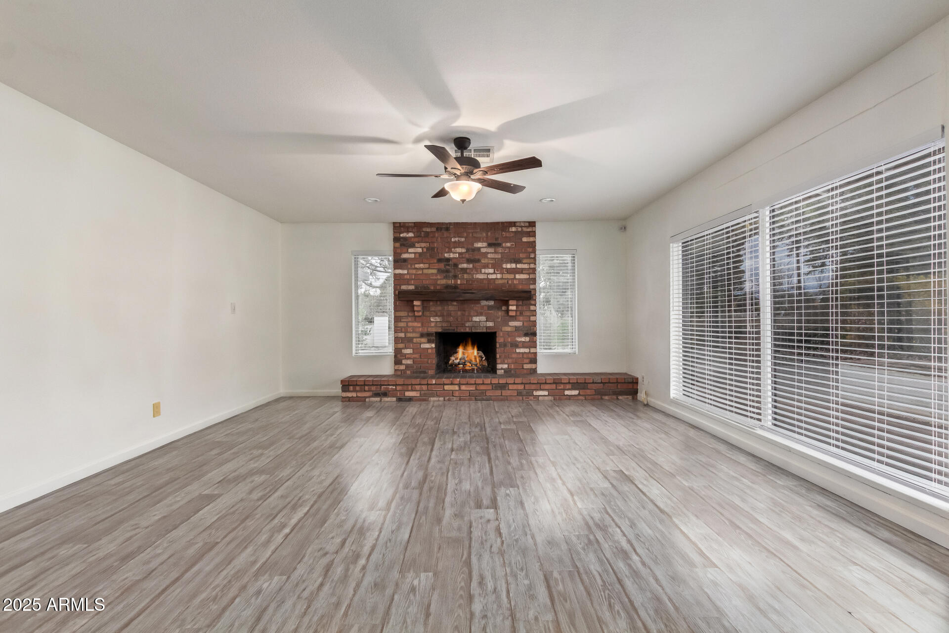 5401 East Exeter Boulevard Phoenix, AZ 85018 - Photo 13 of 47 an empty room with windows fireplace and a wooden floor