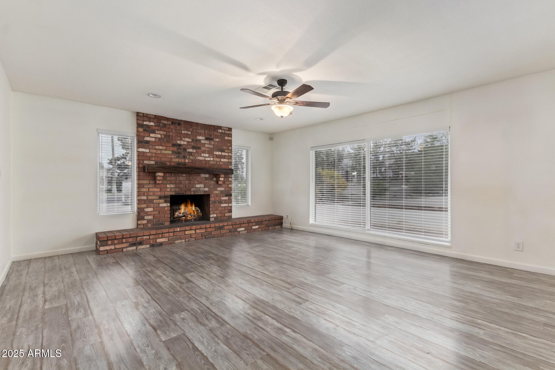 5401 East Exeter Boulevard Phoenix, AZ 85018 - Photo 14 of 47 a view of an empty room with wooden floor fireplace and a window