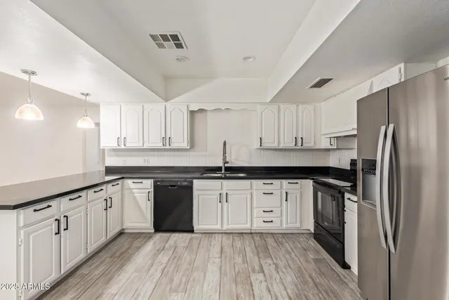 a kitchen with granite countertop a sink a counter space stainless steel appliances and cabinets