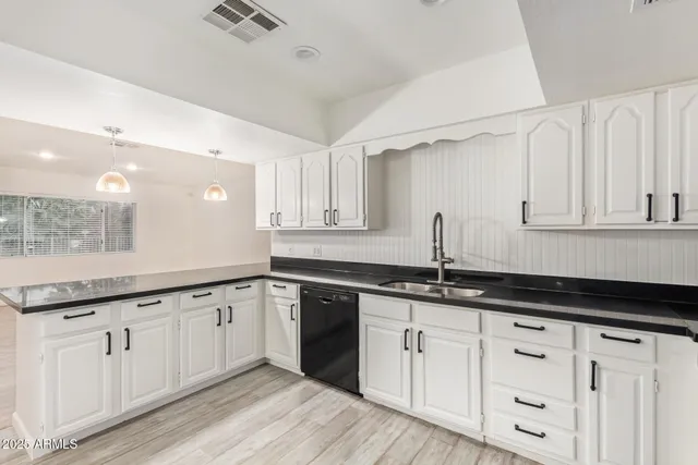 a kitchen with white cabinets a sink and dishwasher