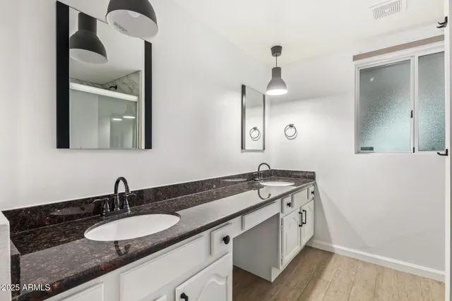 a bathroom with a granite countertop sink and a mirror