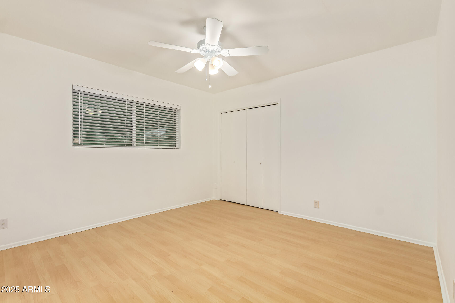 5401 East Exeter Boulevard Phoenix, AZ 85018 - Photo 30 of 47 an empty room with a chandelier fan and windows