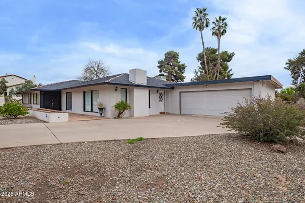 front view of a house with a yard and a garage