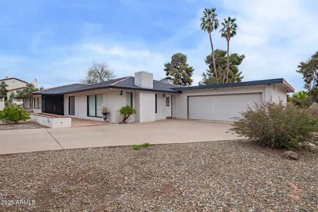 front view of a house with a yard and a garage