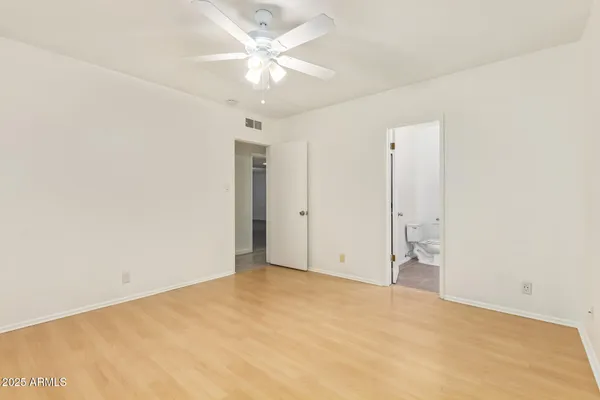 an empty room with a ceiling fan and a window