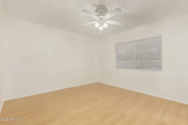 an empty room with a chandelier fan