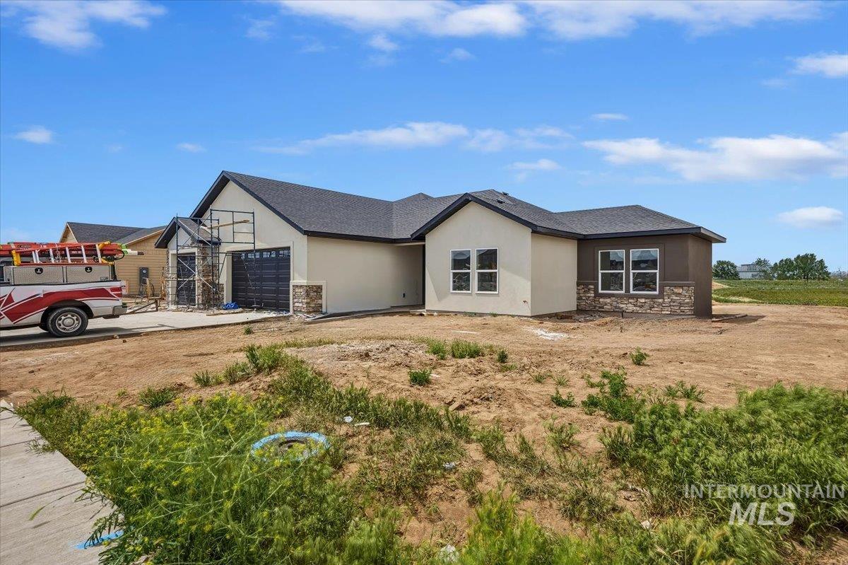 New construction residence featuring stucco and stone veneer exterior