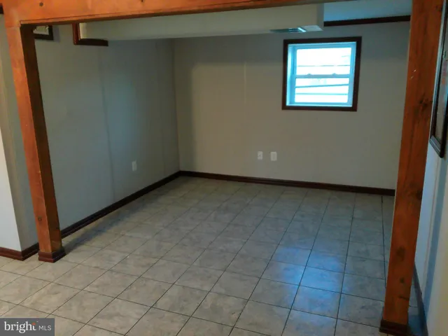 a view of a small space with wooden floor and a window