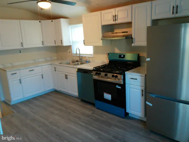 a kitchen with stainless steel appliances granite countertop a stove a sink and a refrigerator