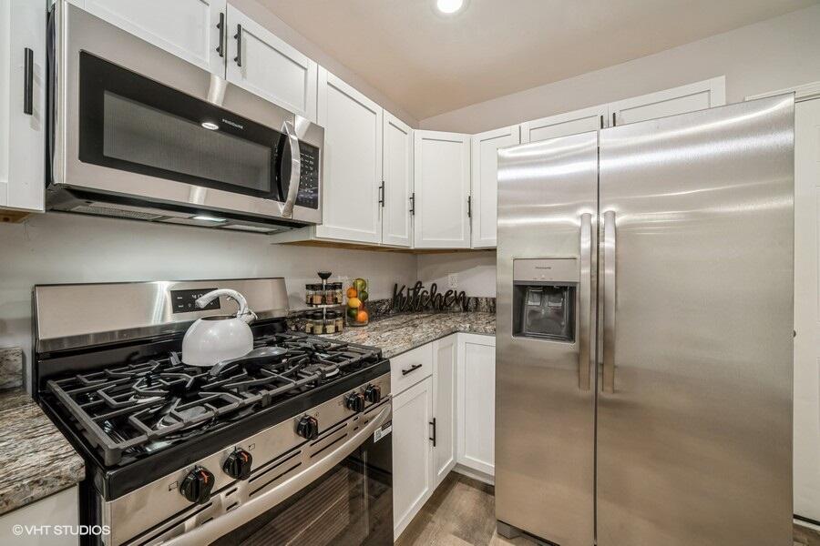 1132 Cleveland Street Hammond, IN 46320 - Photo 12 of 30 a kitchen with stainless steel appliances granite countertop a stove and a microwave