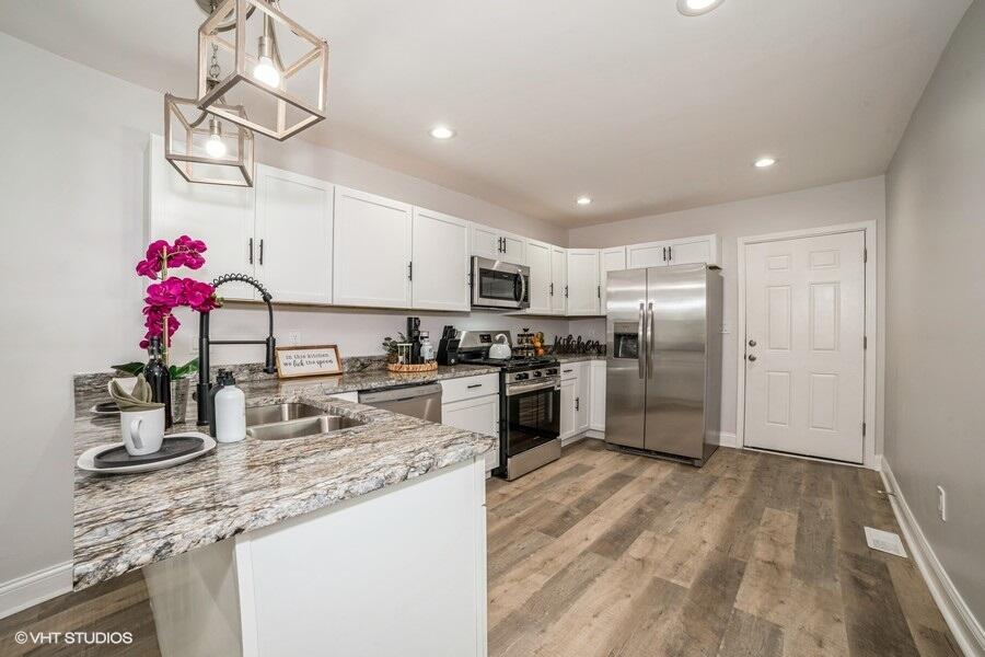1132 Cleveland Street Hammond, IN 46320 - Photo 9 of 30 a kitchen with granite countertop kitchen island stainless steel appliances a refrigerator sink and microwave