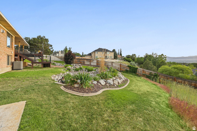 2342 Charros Road Sandy, UT 84092 - Photo 93 of 94 Expansive backyard featuring a multi-level wood deck, a rock garden with mature plantings, and a wooden perimeter fence