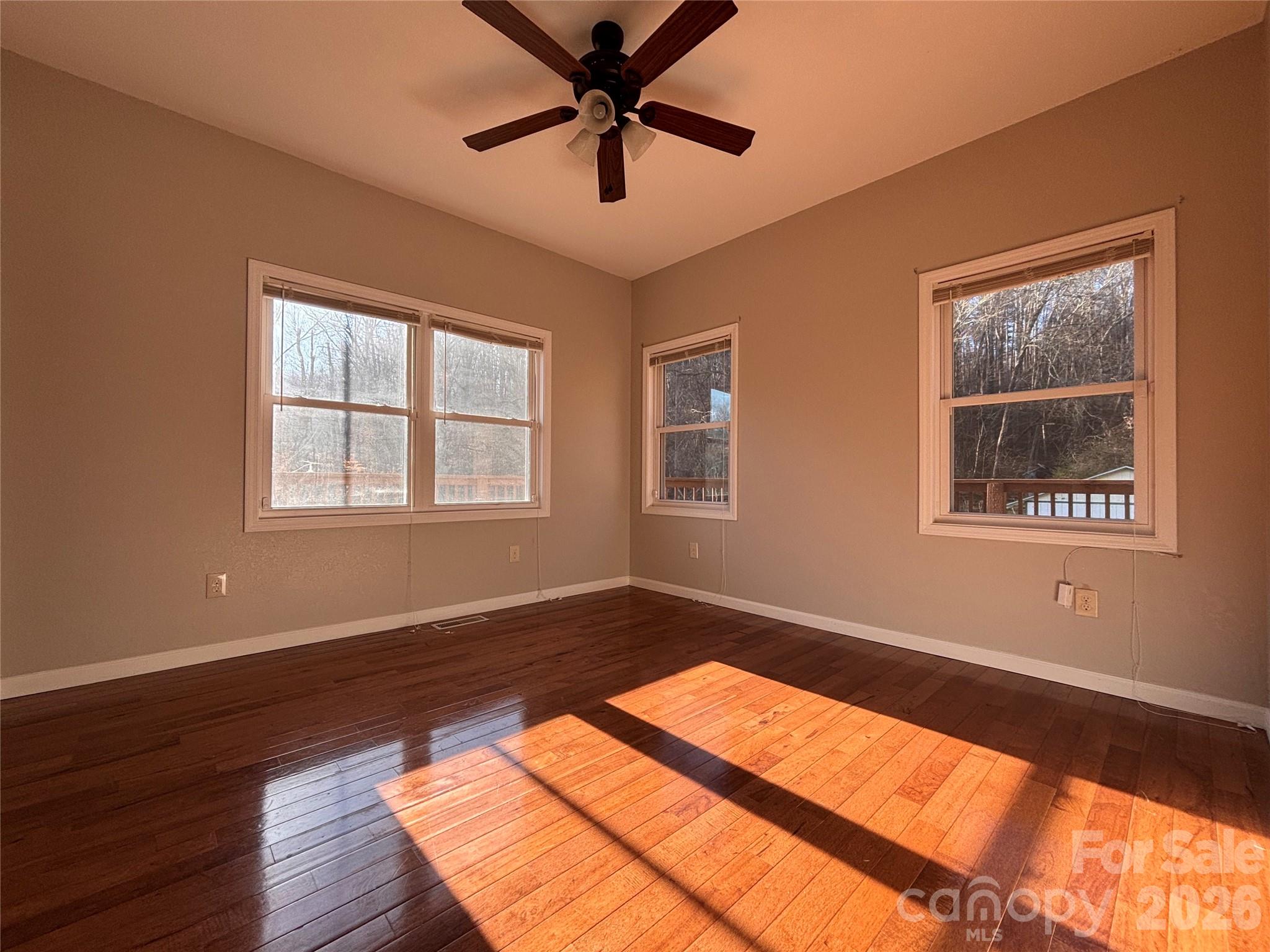250 Duckett Cove Road Waynesville, NC 28786 - Photo 12 of 23 a view of an empty room with window and wooden floor