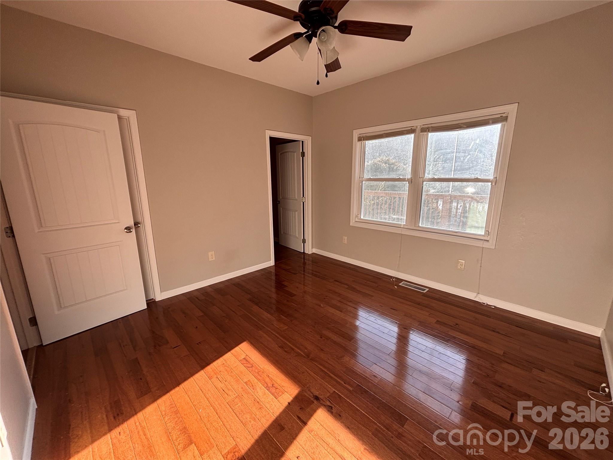 250 Duckett Cove Road Waynesville, NC 28786 - Photo 13 of 23 a view of an empty room with wooden floor and a window