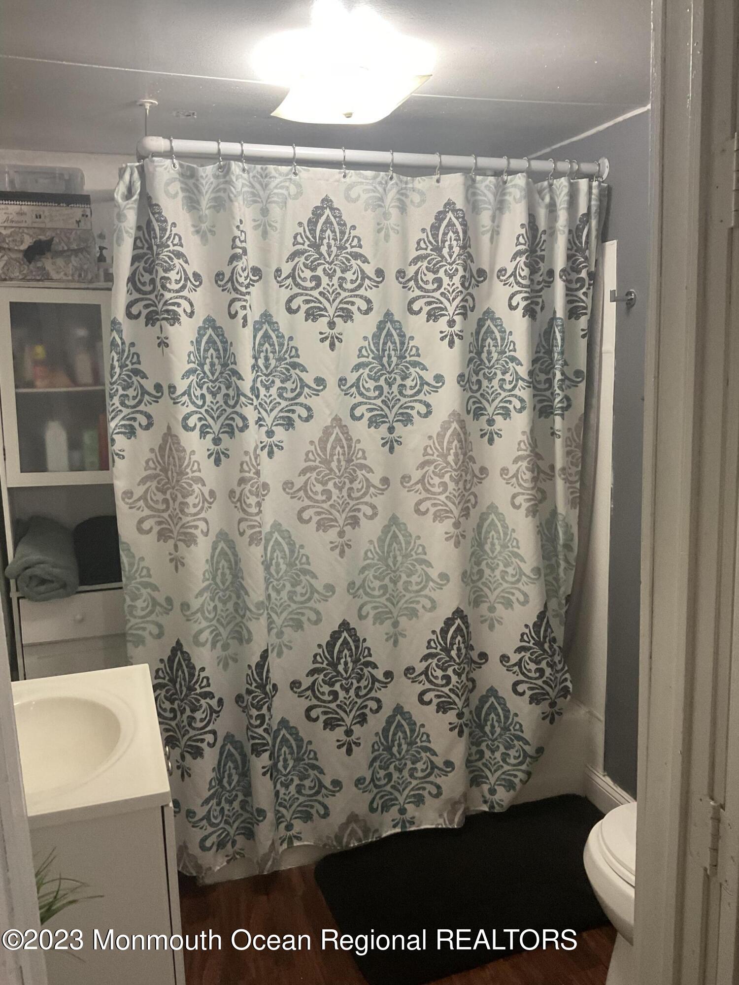 87 Cedarhurst Road Brick, NJ 08723 - Photo 8 of 14 a bathroom with a shower curtain and a sink