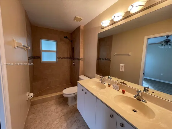 a bathroom with a double vanity sink mirror and toilet