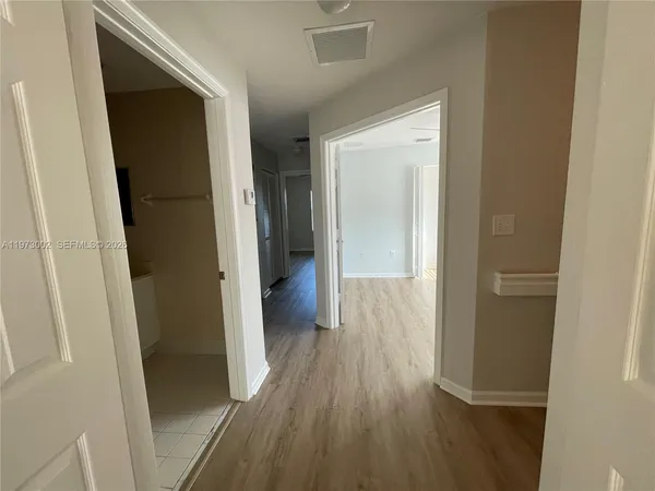 a view of a hallway with wooden floor