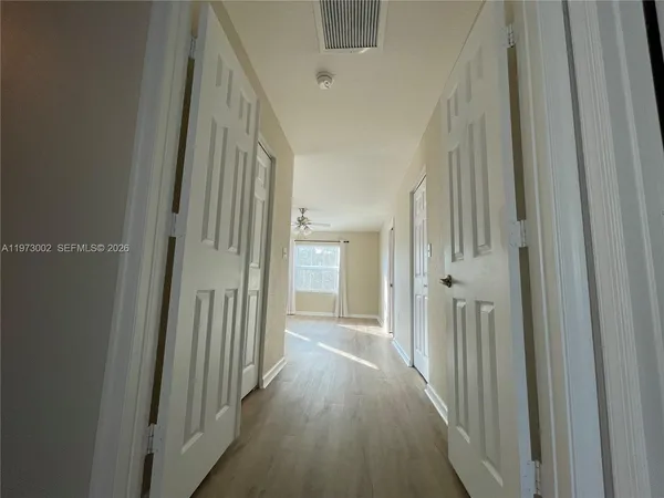 a view of a hallway with wooden floor