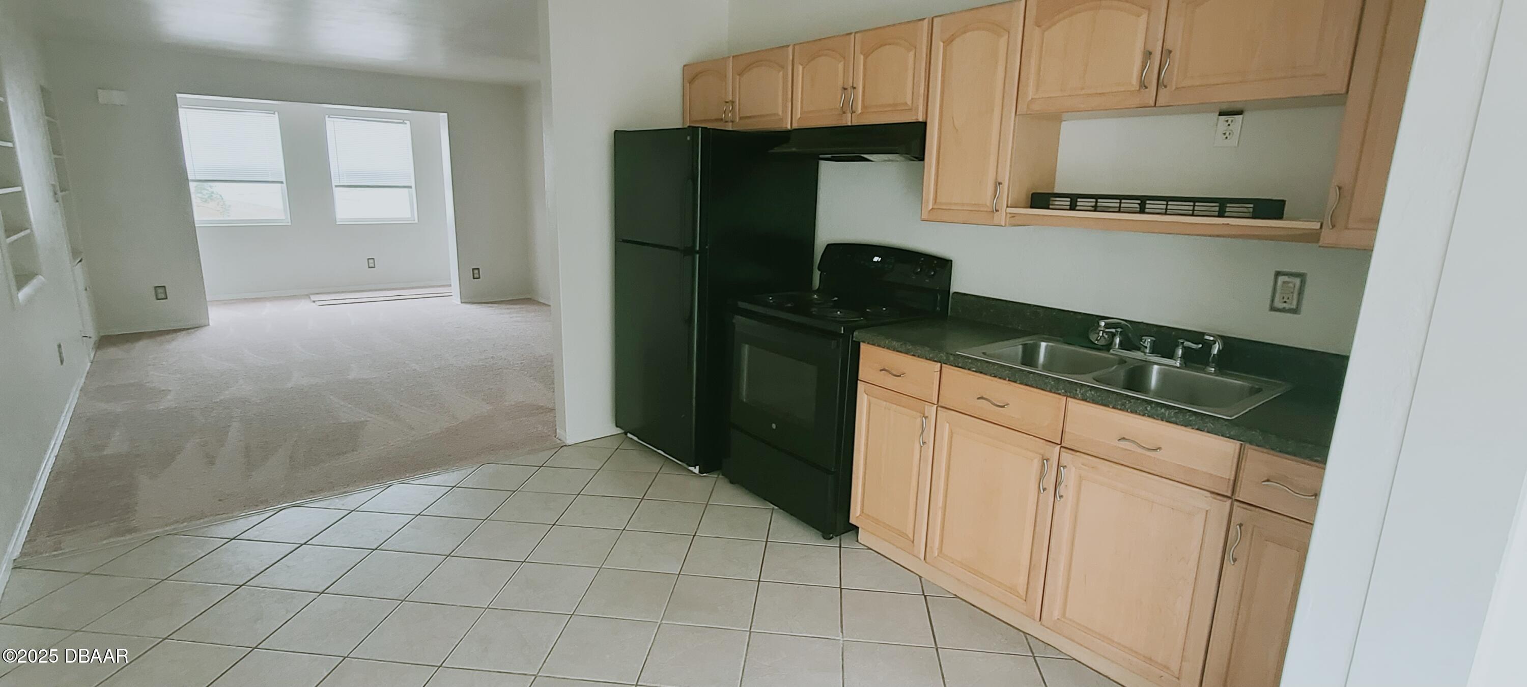 54 Seaside Drive Ormond Beach, FL 32176 - Photo 5 of 12 a kitchen with a refrigerator stove and cabinets