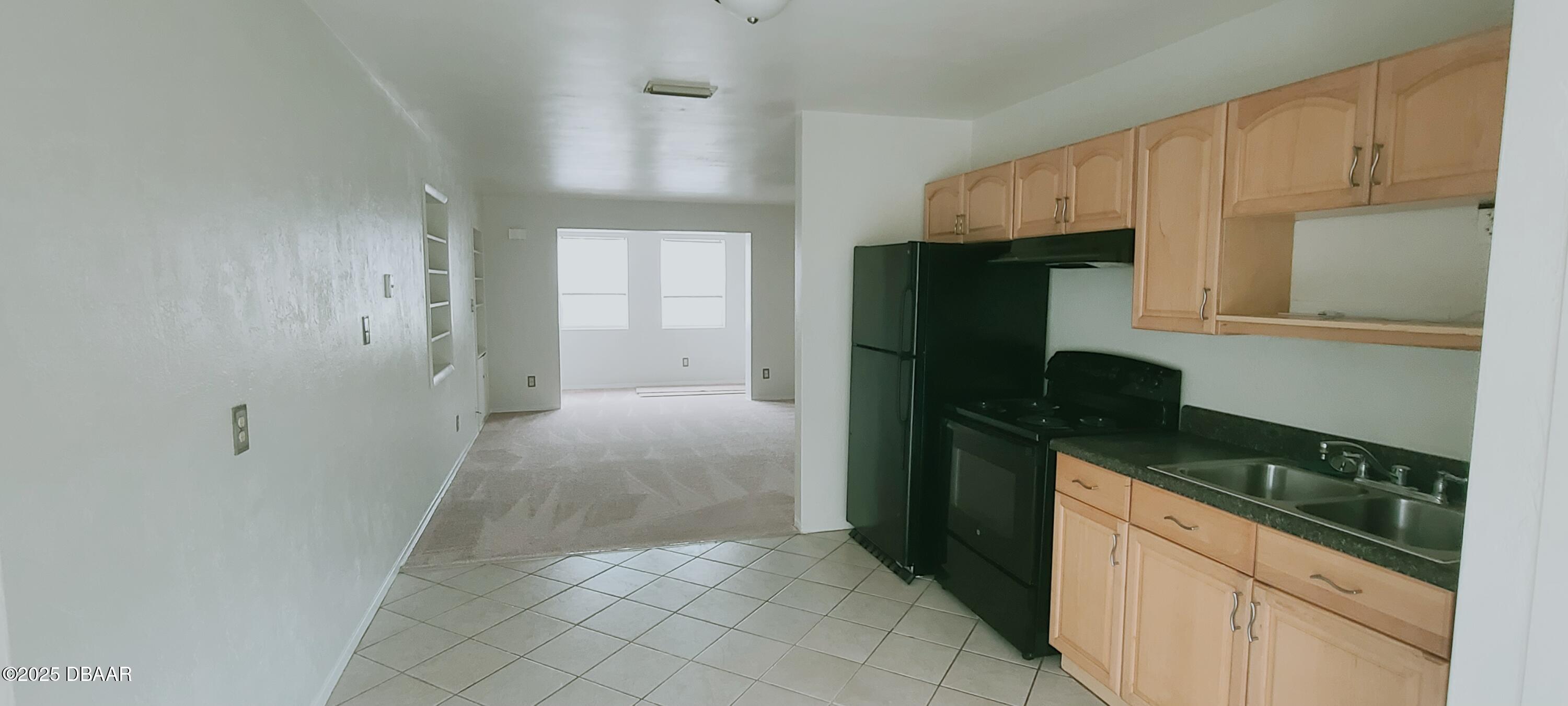 54 Seaside Drive Ormond Beach, FL 32176 - Photo 6 of 12 a kitchen with a refrigerator and cabinets