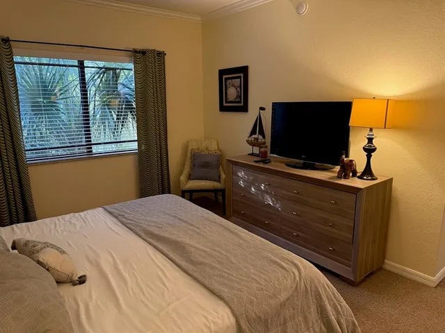 a bed sitting in a bedroom next to a lamp