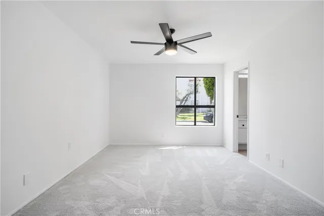 a view of a livingroom with a ceiling fan and carpet