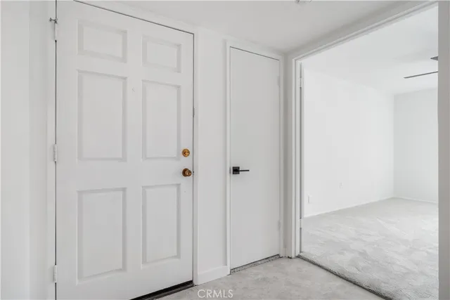 a view of a room with a stylish ceiling fan and entryway