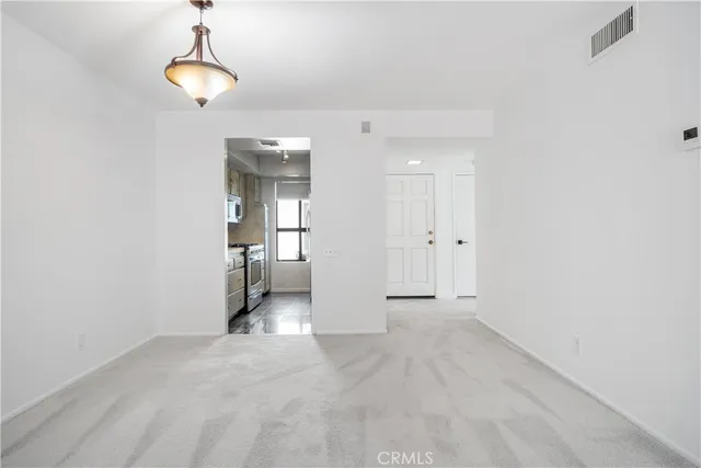 a view of a room with a stylish ceiling fan and entryway
