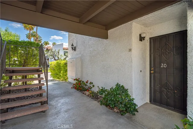 a view of a house with a yard and palm trees