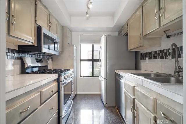 a kitchen with stainless steel appliances granite countertop white cabinets and a stove