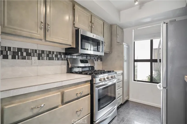 a kitchen with stainless steel appliances a sink a stove and cabinets
