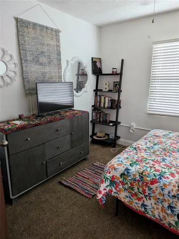 a bedroom with a bed and a lamp on dresser