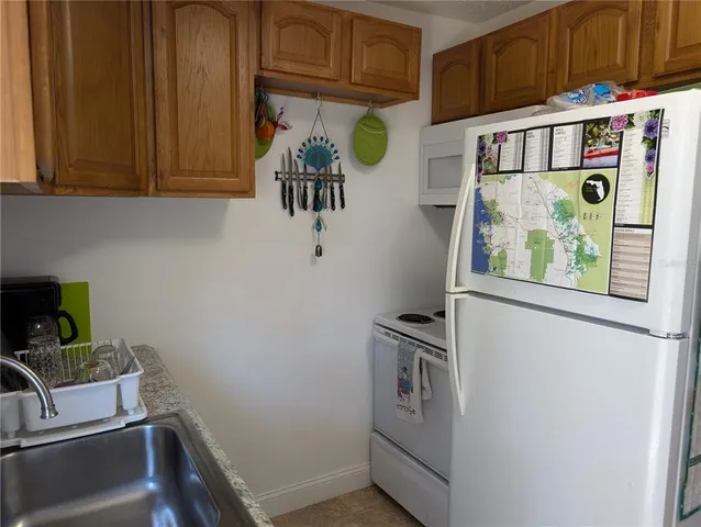 a utility room with fridge dryer and washer