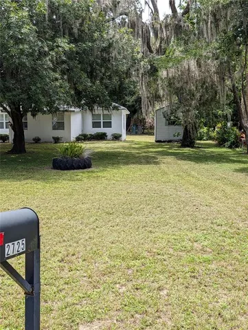 a front view of a house with yard and green space