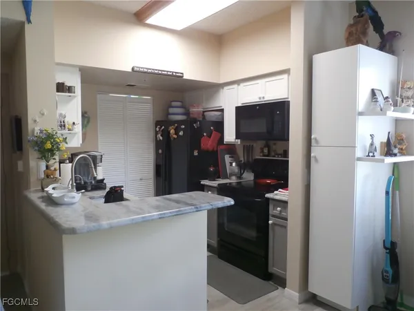 a kitchen with stainless steel appliances kitchen island granite countertop a refrigerator and a sink