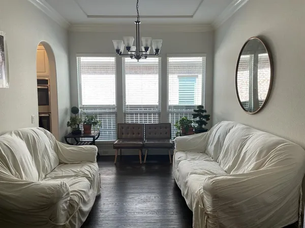 a living room with furniture and a chandelier