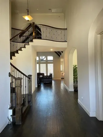 a view of a hallway with wooden floor and stairs