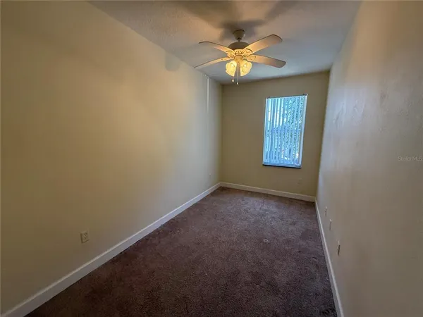 a view of an empty room with chandelier and a window