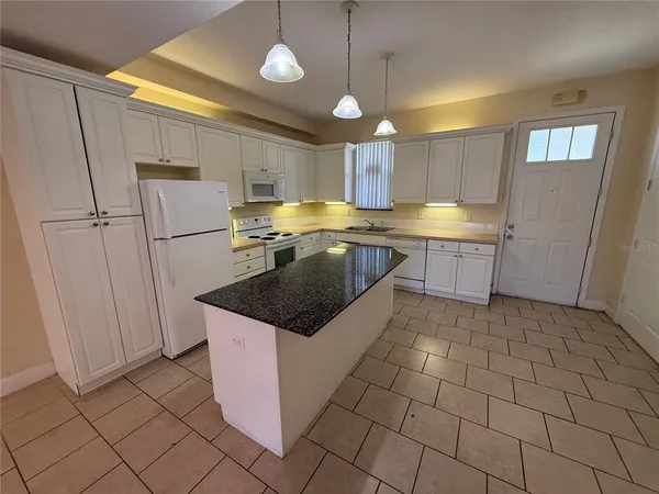 a kitchen with a sink a counter space cabinets and appliances