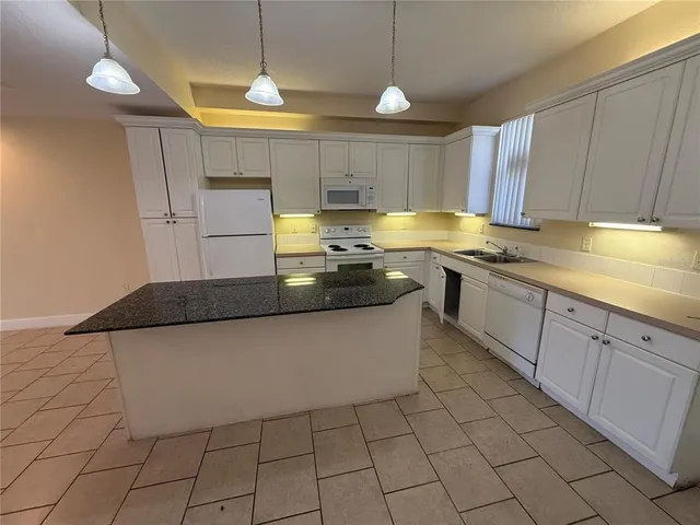 a kitchen with stainless steel appliances granite countertop a sink a stove counter space and cabinets