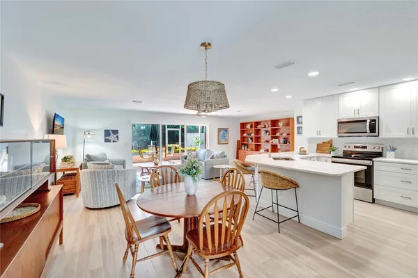 a kitchen with stainless steel appliances kitchen island granite countertop a sink and a refrigerator