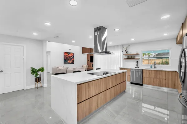 a kitchen with stainless steel appliances a kitchen island a stove a table and chairs